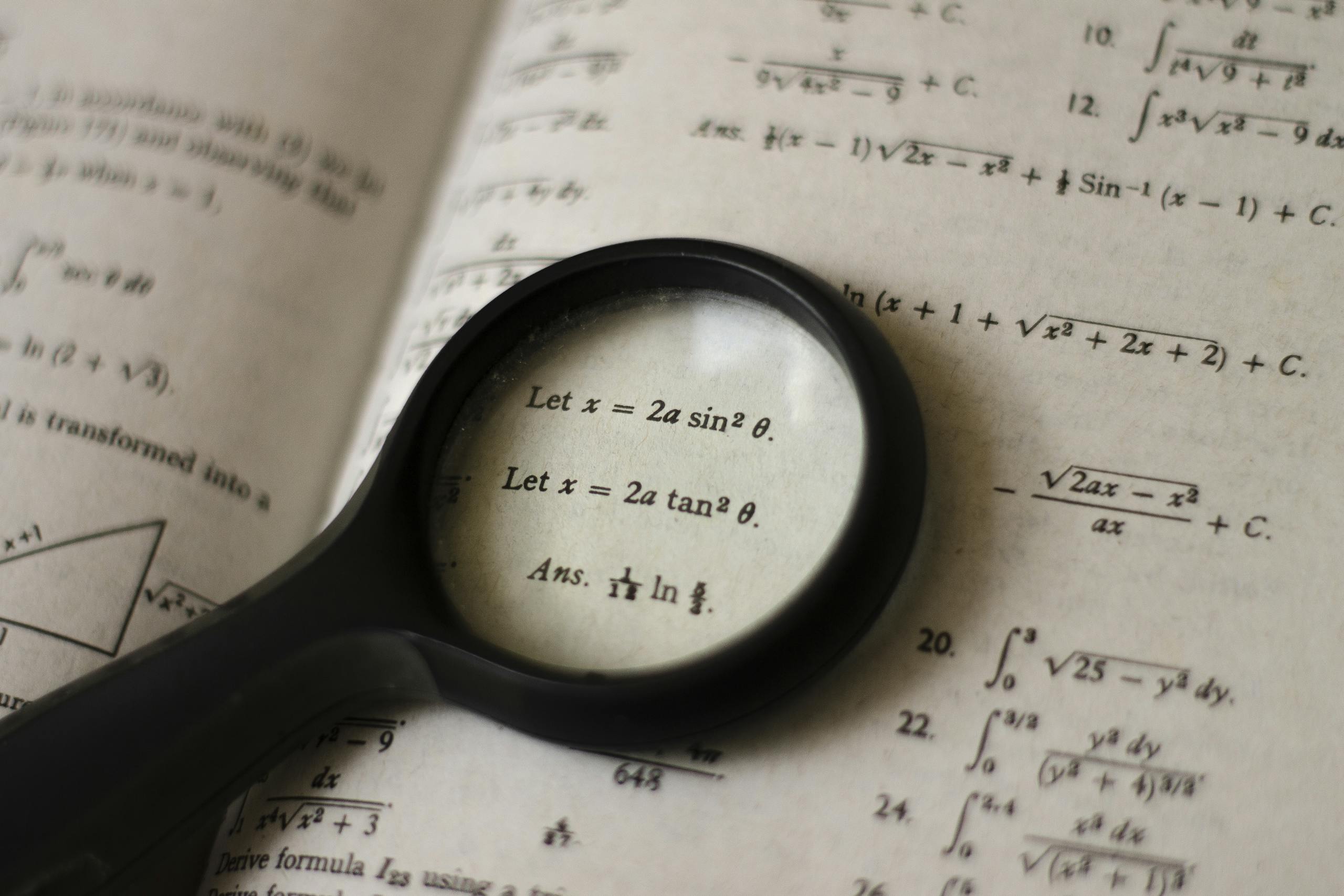 A magnifying glass focusing on mathematical equations in a textbook, symbolizing detailed study.